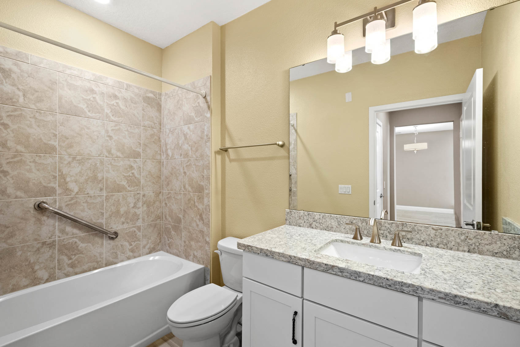 bathroom with marble counter with sink and tub